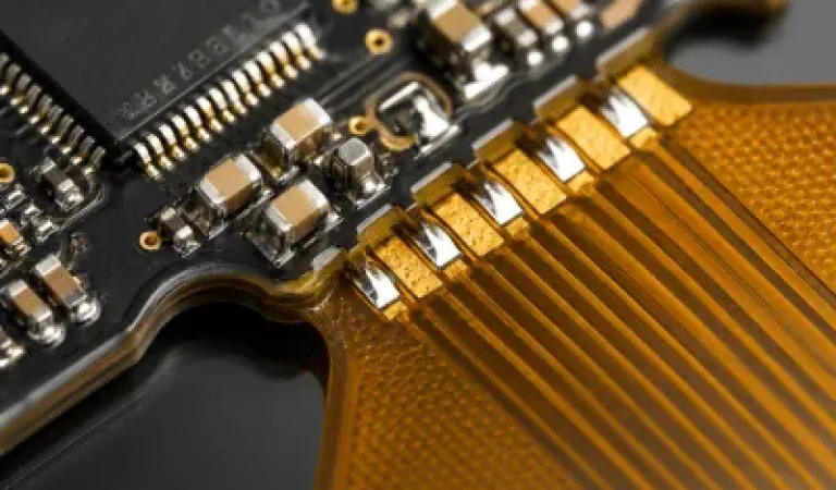 Rigid-flex PCBA assembly detail showing SMT components on the rigid section transitioning to a matte polyimide flexible circuit area for complex electronic manufacturing.